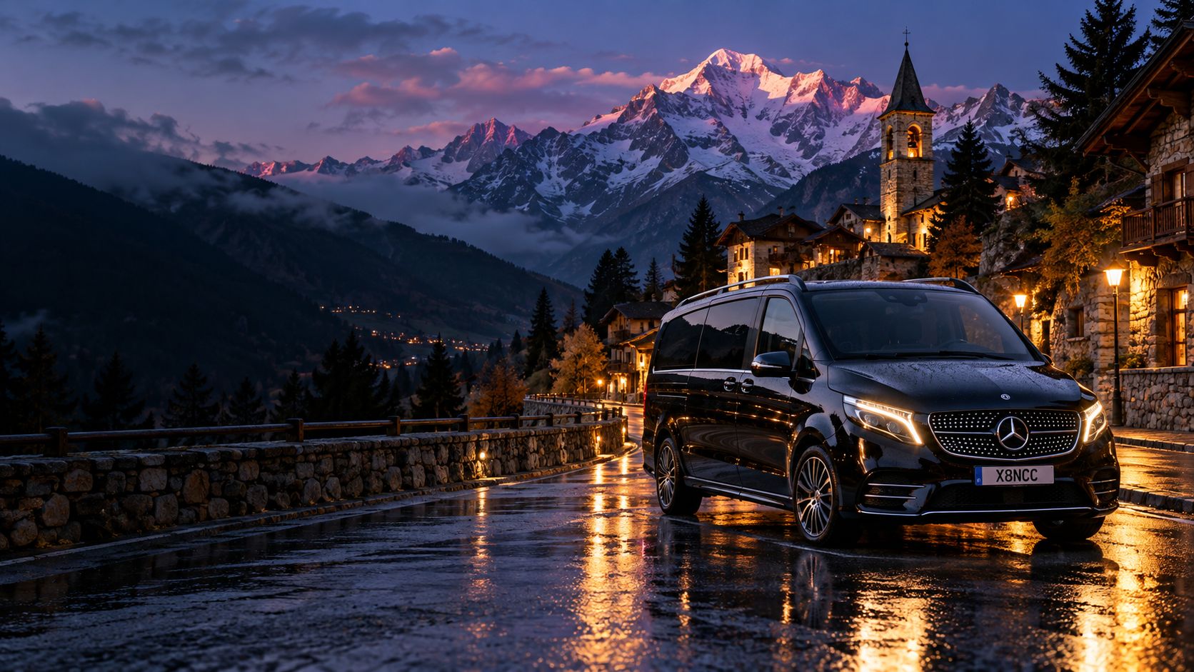 Mercedes Classe V nera su una strada di montagna in Valle d’Aosta, al tramonto, con il campanile di un borgo e il massiccio del Monte Bianco sullo sfondo